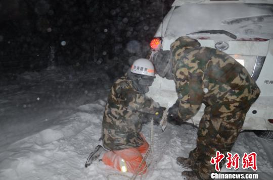 圖為消防救援人員給被困車輛安裝救援繩?！±罱?攝